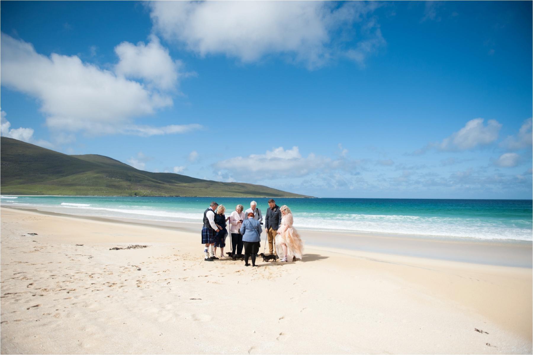 An elopement with just a few close family members and three favourite dogs on Scarista Beach on the Isle of Harris with blue skies and white sands. 