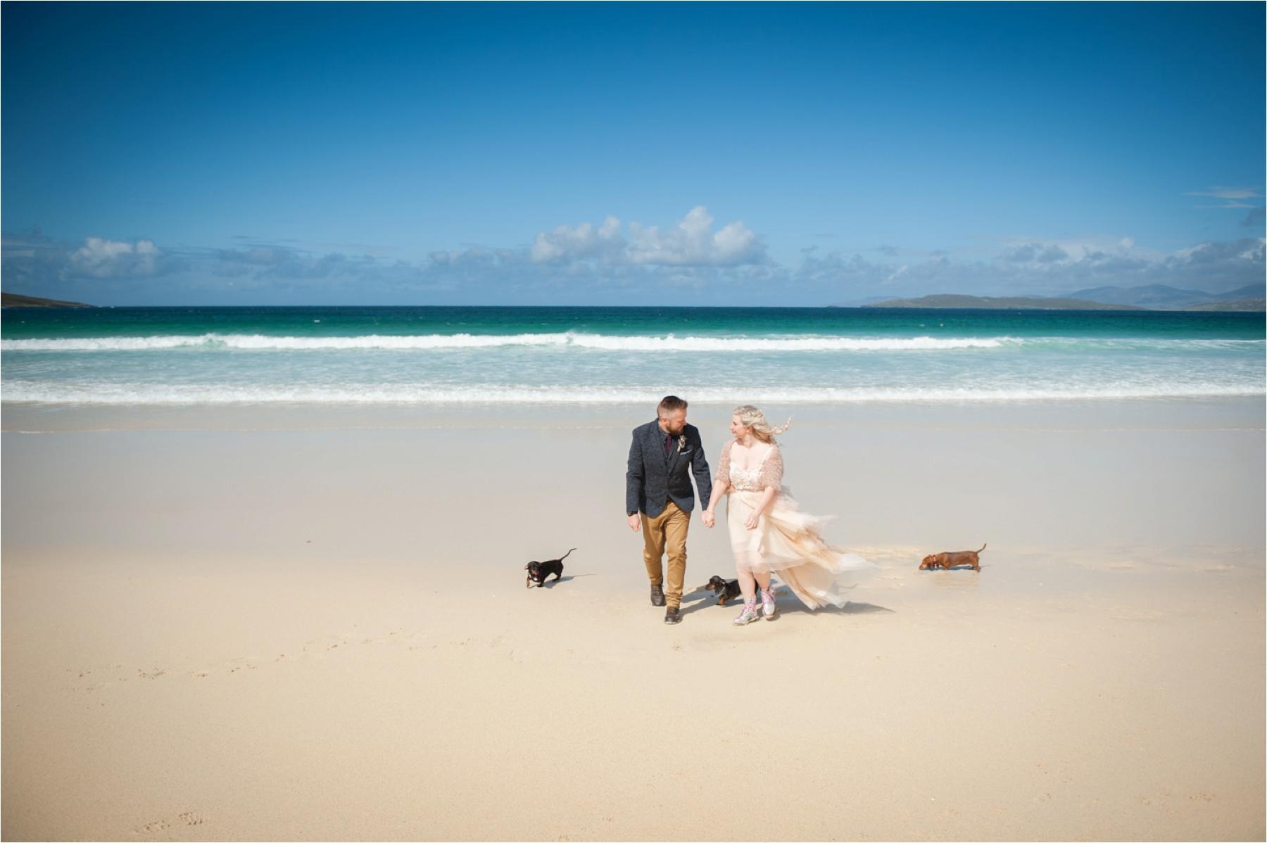 Elopement photography of a couple and their dogs on Scarista Beach on the Isle of Harris. 