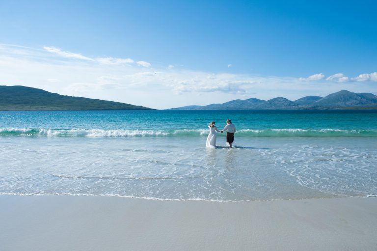 An Isle of Harris elopement with the bride and groom walking along the sand.