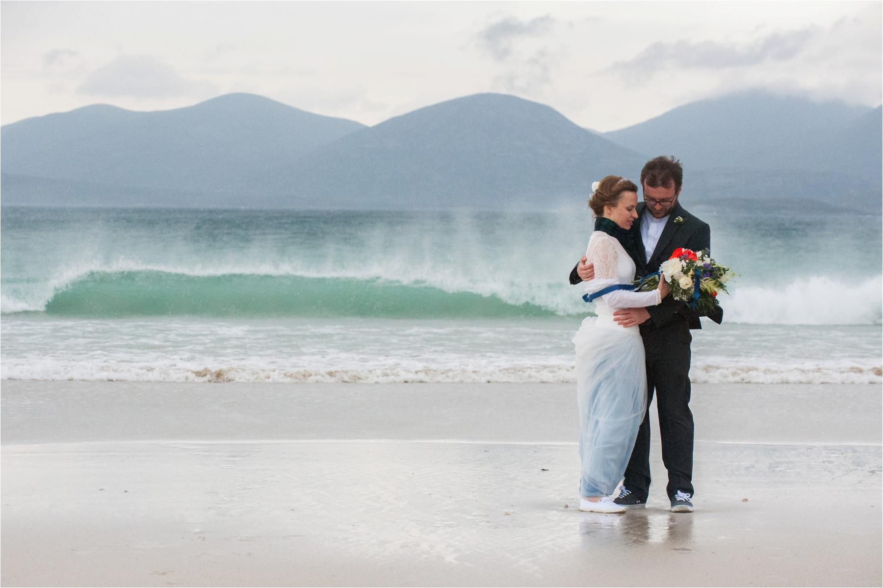 A bride and groom stand alone on Scarista Beach for their Scottish elopement in the Outer Hebrides. 
