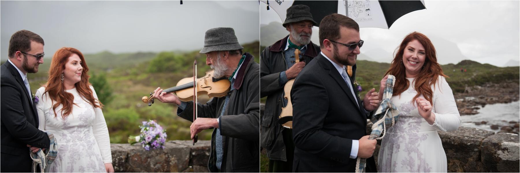 A fiddler plays a requested song from the bride during their outdoor ceremony in the Scottish Highlands. The ceremony took place on the old bridge at Sligachan on the Isle of Skye. 