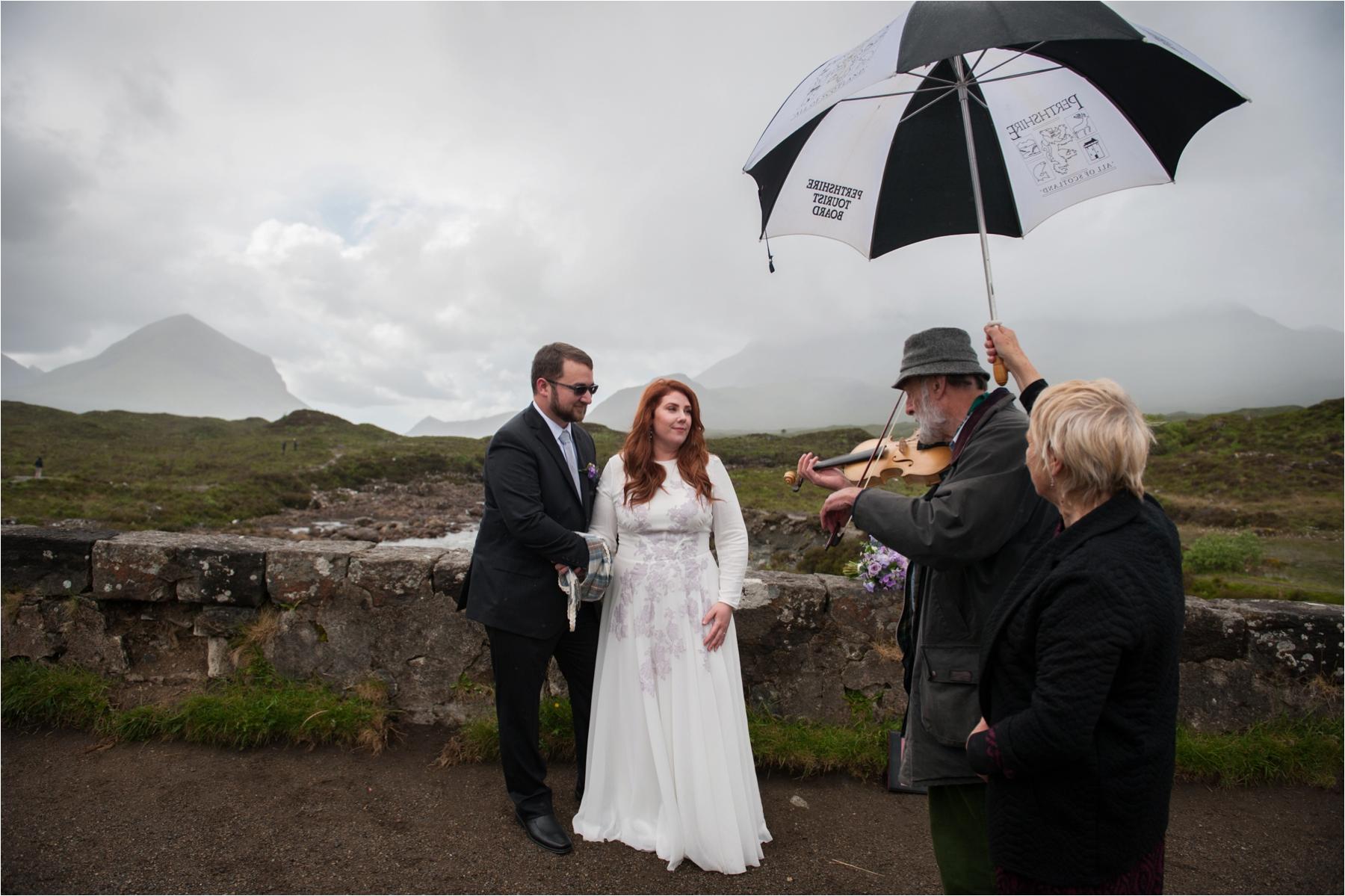 A fiddler plays during an outdoor wedding ceremony on the old bridge at Sligachan on the Isle of Skye. 