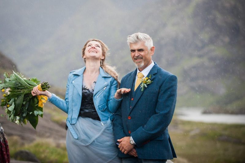 Couple standing in the rain during their wedding ceremony on the Isle of Skye near Loch Coruisk.